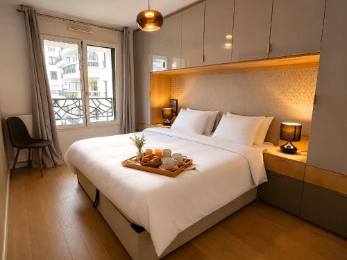 a bedroom with a large bed with a tray of fruit on it at Le Penthouse de Levallois in Levallois-Perret