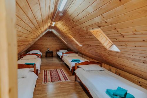 a room with four beds in a wooden cabin at Hanul Morii in Ciucea