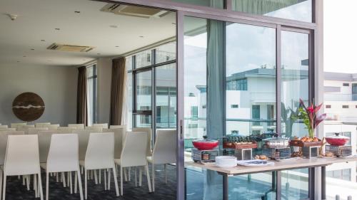 a dining room with windows and a table and chairs at Hotel English Point Marina & Spa in Mombasa