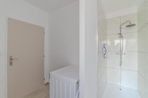 a white bathroom with a shower and a toilet at La Demeure des Sources - Iris - Avec climatisation in Bourbon-Lancy