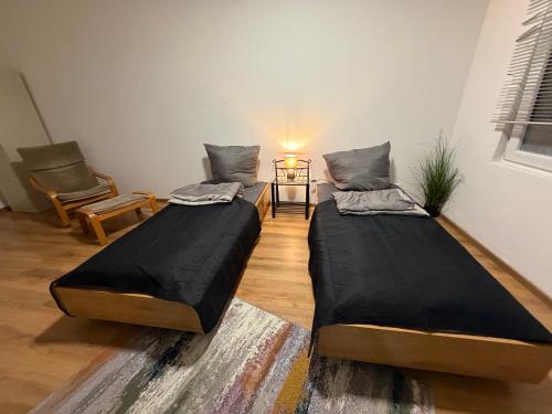 two beds in a room with a table and a chair at Sky Appartment in Koblenz