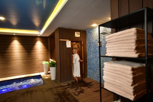 a little girl standing in a bathroom with a tub at Best Western Plus Paradise Hotel Dilijan in Dilijan