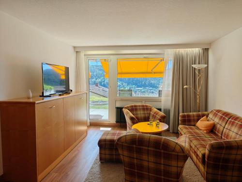 a living room with two couches and a television at Hochwald Hotel & Apartment in Bad Liebenzell