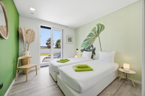 a bedroom with a large white bed and a balcony at Al Casa Branca in Lourinhã