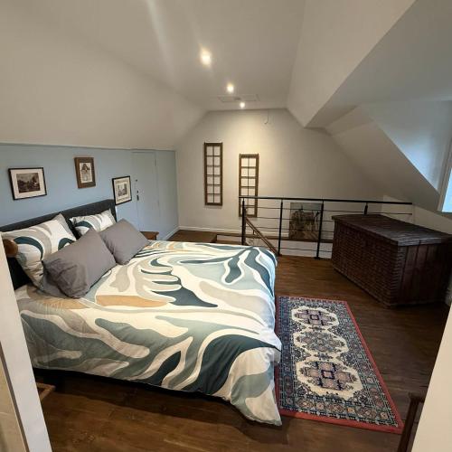 a bedroom with a large bed in a attic at Maisons d'antan Giverny in Giverny