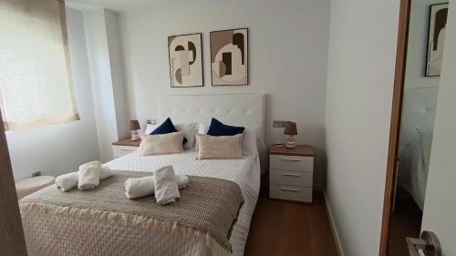 a bedroom with a bed with towels on it at Las gaviotas,playa,piscinayparking in Malpica