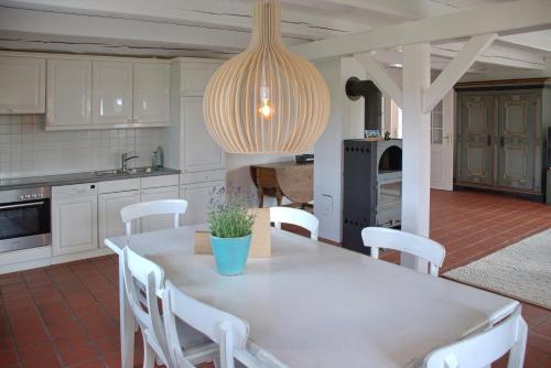 a kitchen with a white table and white chairs at Van Gunst Hüs, Alkersum in Alkersum