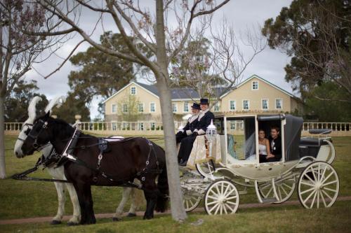 a horse drawn carriage with a bride and groom at Peel Manor House in Karnup