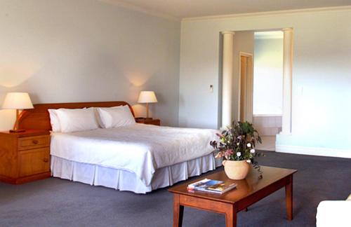 a hotel room with a bed and a table with a coffee table at Peel Manor House in Karnup