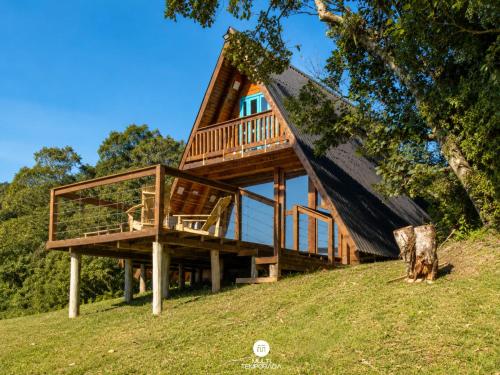 a tree house on a hill with a deck at Rancho Sol Poente - Rancho Queimado - SC in Rancho Queimado