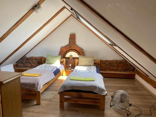 a attic room with two beds and a couch at SARNOGRÓD - Agroturystyka z alpakami in Babięta