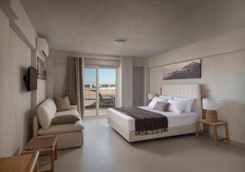 a bedroom with a bed and a chair and a balcony at Hotel Sarti Beach in Sarti