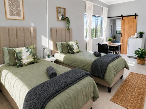 a bedroom with two beds and a living room at The Lion's Den in George