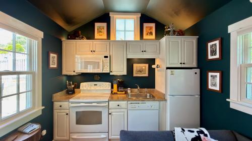 a kitchen with white appliances and green walls at Helltown Hideaway - Private Patio, Walk Anywhere, Free Parking in Provincetown
