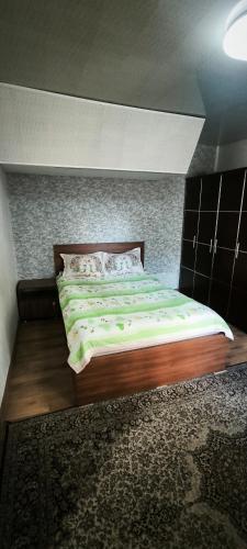 a bedroom with a large bed with green sheets at Квартира у бульвара 1 in Batumi