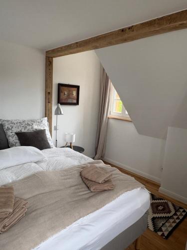a bedroom with a large white bed and a window at An der Obstwiese in Untergut