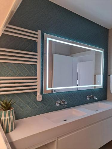 a bathroom with a sink and a mirror at Beachfront 3bdr apt on Marginal Boulevard in São Martinho do Porto