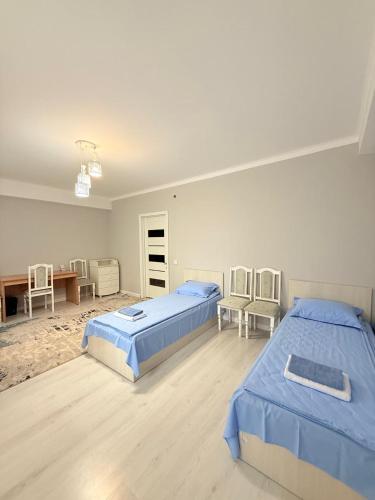 a bedroom with two beds and a table and chairs at Jaily in Astana