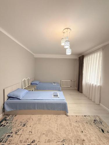 a bedroom with two beds and a chandelier at Jaily in Astana