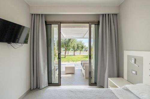 a bedroom with a bed and a sliding glass door at Hotel Baia Di Trainiti in Vibo Valentia