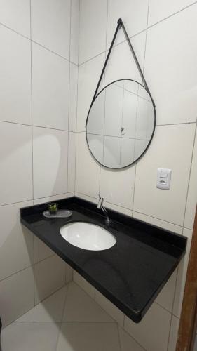 a bathroom with a sink and a mirror at Sobrado Tropical a 1 Km da faculdade Unic e UFMT in Cuiabá