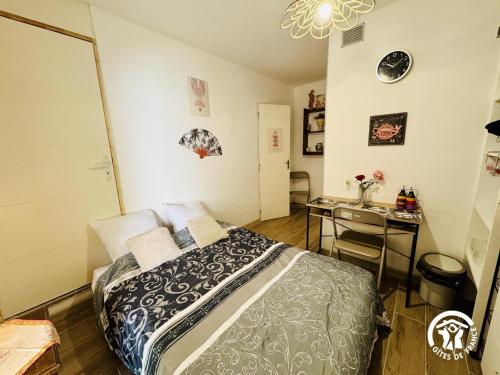 a bedroom with a bed and a desk in it at L'oustal de sandy in Cascastel-des-Corbières