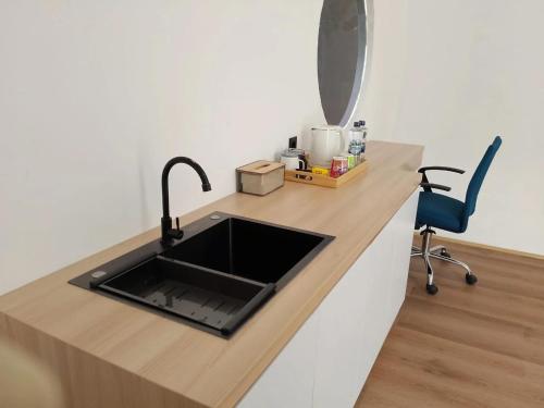 a kitchen counter with a sink and a blue chair at Shira Villa in Seturan