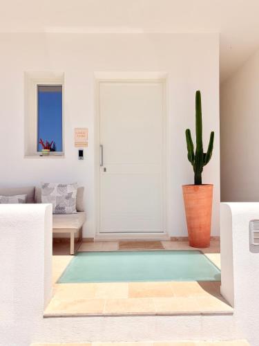 ein Wohnzimmer mit einem Kaktus und einer Tür in der Unterkunft Camere Assúd in Santa Maria di Leuca
