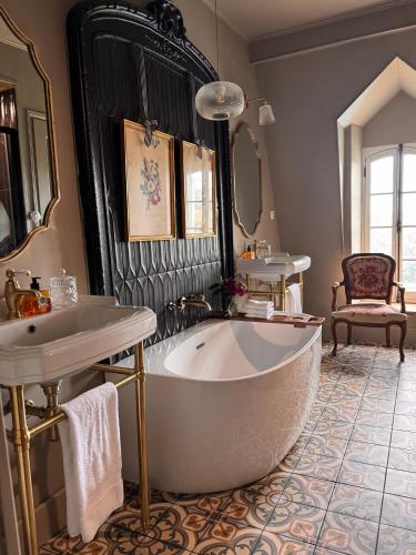 a bathroom with a large tub and a sink at Chateau Forest in Arette