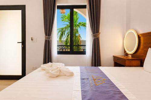 a bedroom with a bed with a mirror and a window at TamCoc Golden Mountain Homestay in Vũ Lâm