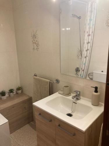 a white bathroom with a sink and a mirror at Habitación privada con zonas compartidas in Castellbisbal