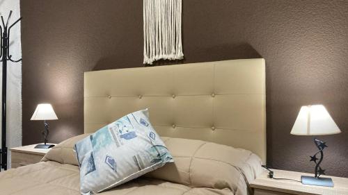 a bedroom with a white bed with two lamps at Habitación privada con zonas compartidas in Castellbisbal