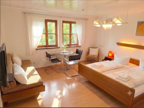 a bedroom with a bed and a living room with a table at Pension Rose-Monteurzimmer & Ferienzimmer - Bodensee-Selbstversorger mit Küchen, Parken & Kaffee & Wlan frei in Ravensburg