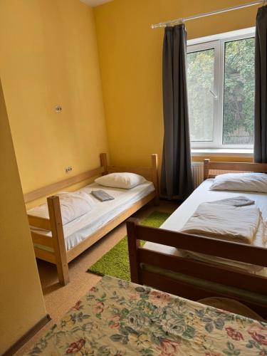 a room with two beds and a window at Guest House KARTA F M in Kamianets-Podilskyi