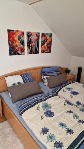 a bedroom with two beds with paintings on the wall at Spessartblick in Heimbuchenthal