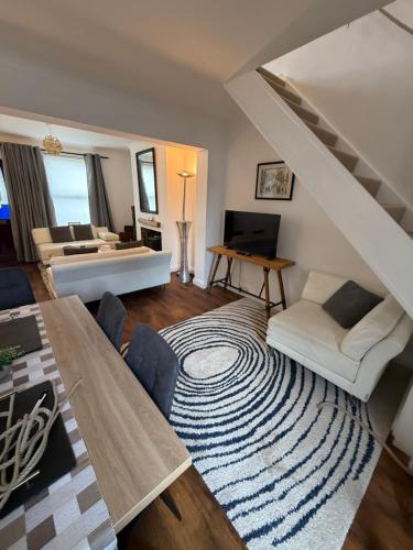 a living room with a staircase and a couch and a table at Stay at 48 in Oulton