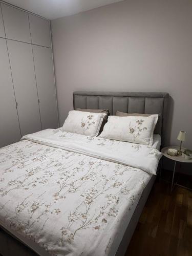 a bedroom with a bed with white sheets and pillows at Apartman Laki in Bijeljina