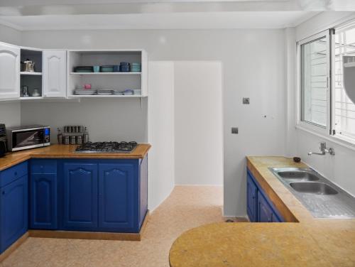 a kitchen with blue cabinets and a sink at Atlas - Appartement moderne in Fez