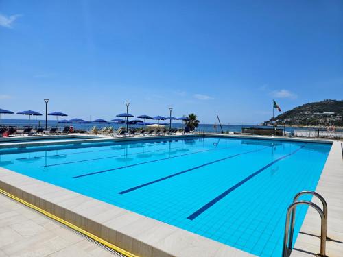 a large swimming pool with blue water at Casa Caribe - Piscina, Spiaggia e Parcheggio inclusi! GRATIS in Sanremo