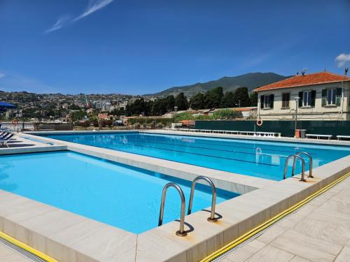a large swimming pool with blue water at Casa Caribe - Piscina, Spiaggia e Parcheggio inclusi! GRATIS in Sanremo