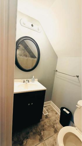 a bathroom with a sink and a mirror and a toilet at Hamilton Central 3BR Family House in Hamilton