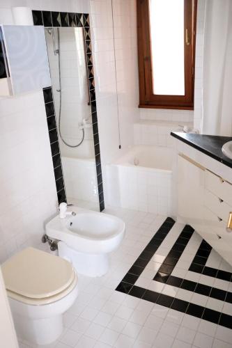 a white bathroom with a toilet and a shower at VillaCycas in Casal Taulero