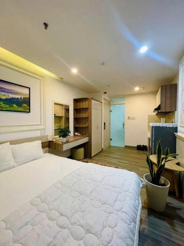a bedroom with a large white bed and a kitchen at Sencoco Hotel in Hà Quảng (4)