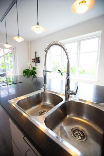 a stainless steel kitchen sink in a kitchen at Luxurious, spacious apartment - Nordic Style in Copenhagen