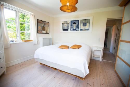 a bedroom with a white bed with two pillows on it at Luxurious, spacious apartment - Nordic Style in Copenhagen