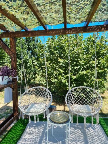 two chairs on a porch with a swing at Vila Stancevic wellness in Sremski Karlovci