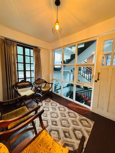 a living room with chairs and a large window at The Urban Hideout in Nuwara Eliya