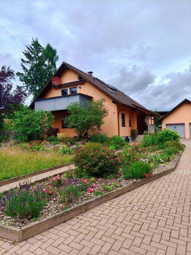 a house with a flower garden in front of it at Ferienwohnung am Keltenwall in Jestetten