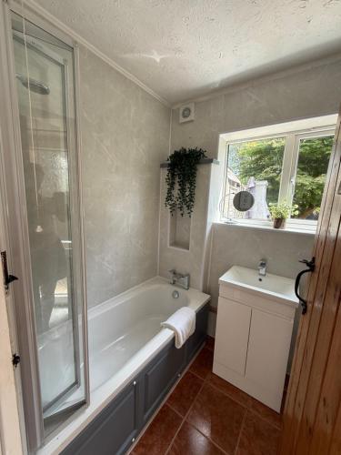 a bathroom with a bath tub and a sink at Stay at 48 in Oulton