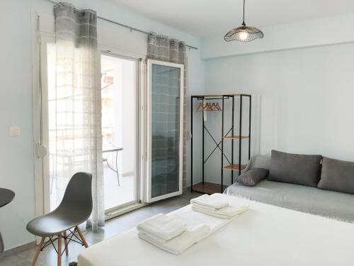 a white living room with a couch and a table at Beachway luxury studio C in Nea Peramos